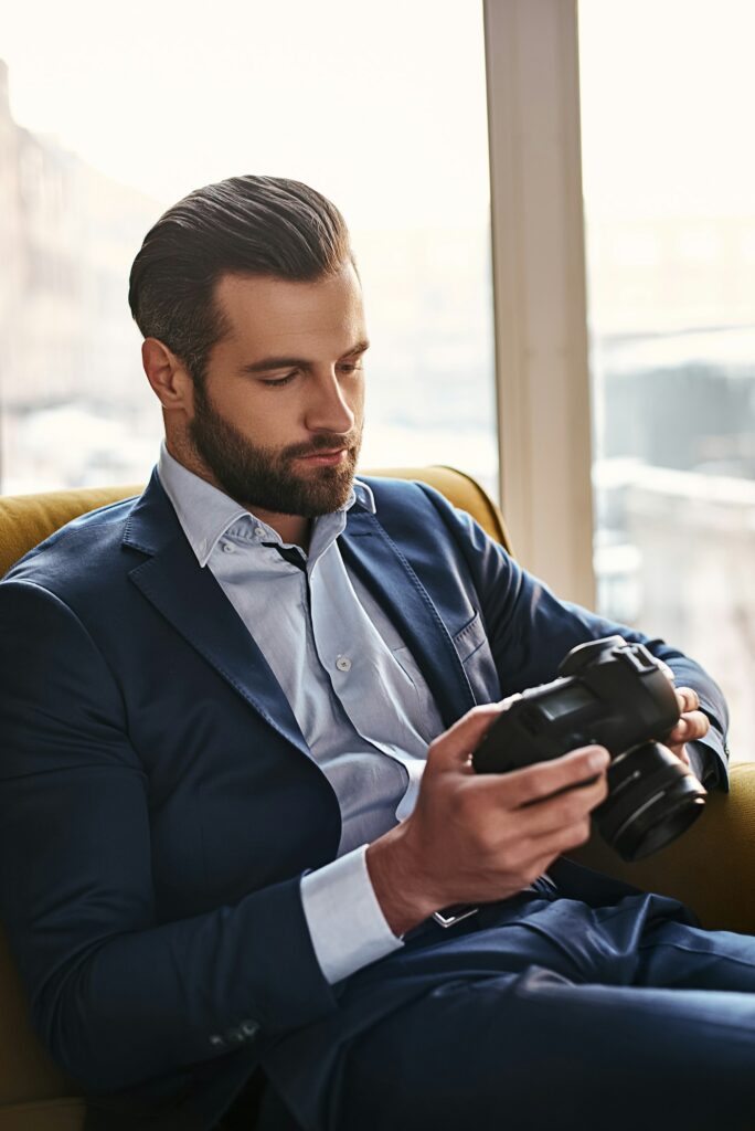 Photography is a great hobby. Close-up portrait of young bearded and well dressed businessman who is